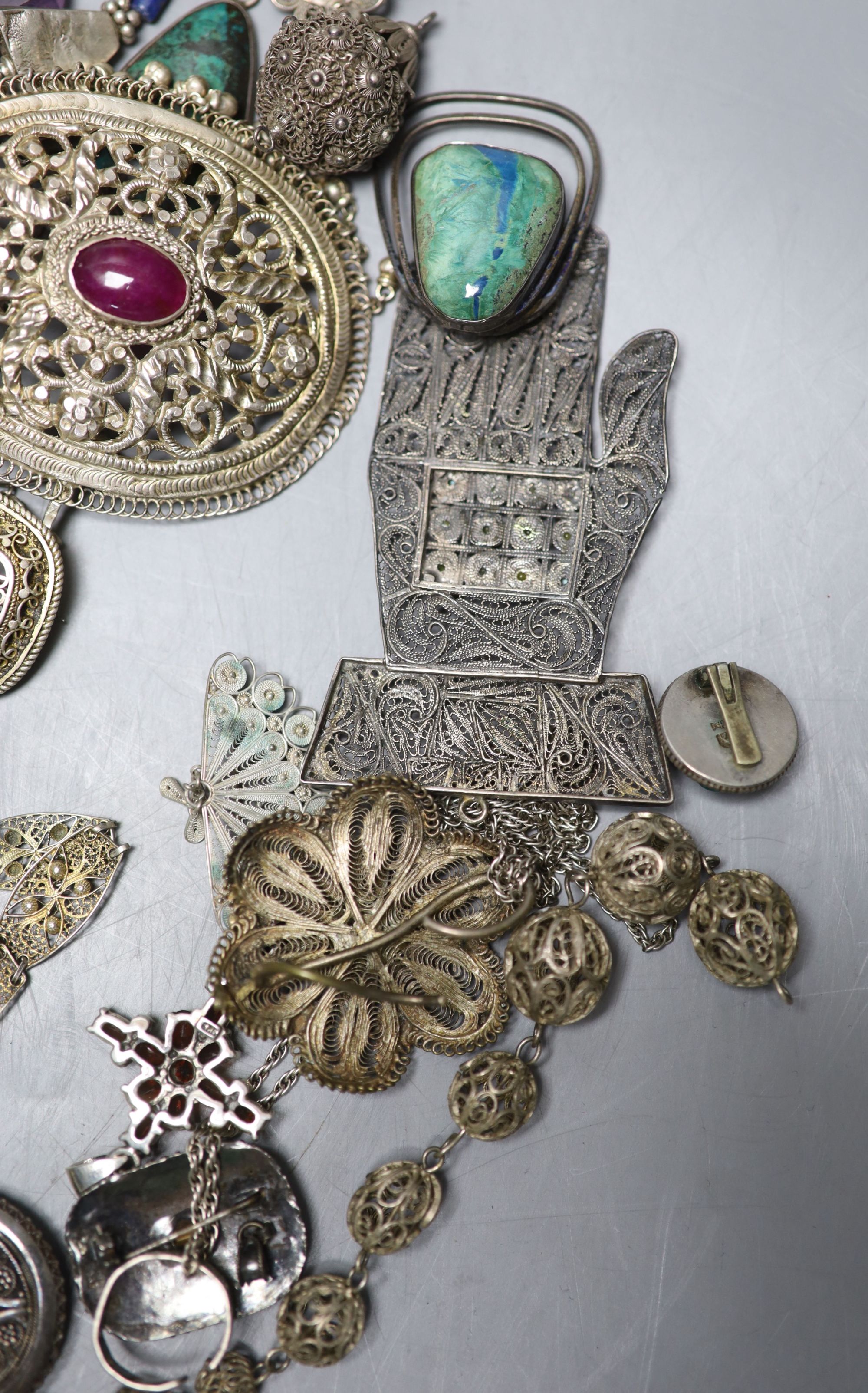 A mixed group of assorted white metal and costume jewellery including locket, brooches and filligree items.